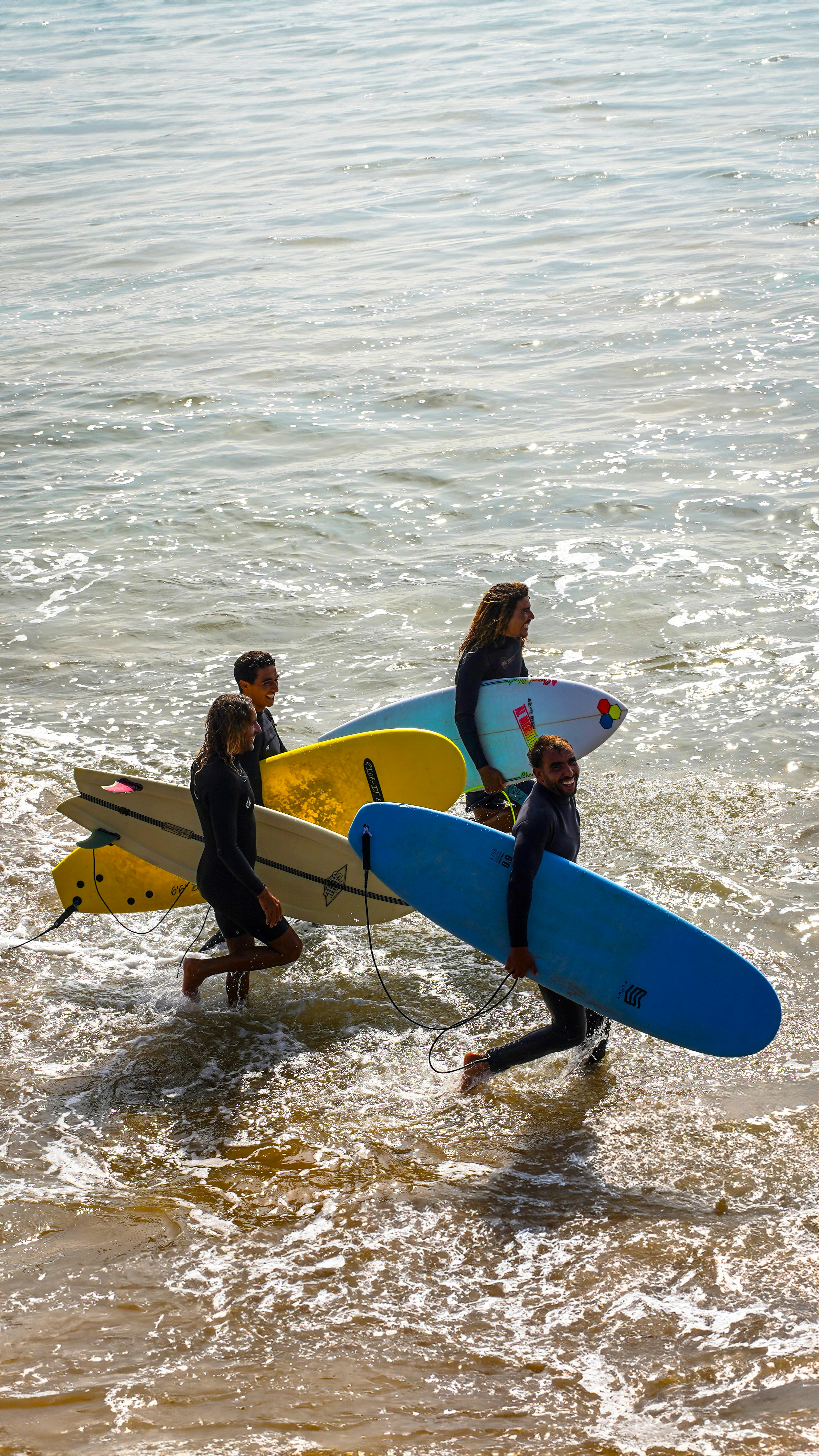 Surf camp group entering ocean together in Portugal